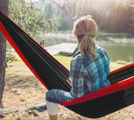 Hamac hikerjoy roșu cu negru montat în natură pentru relaxare